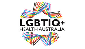 Logo of LGBTIQ+ Health Australia. The text "LGBTIQ+ Health Australia" appears in bold black capital letters at the center, surrounded by a circular pattern of overlapping, multicoloured triangles forming a starburst shape.